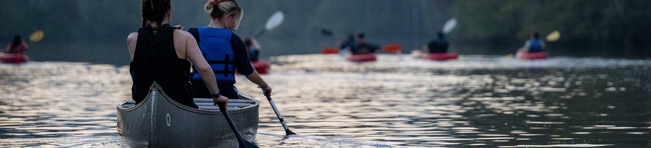 Student on a moon light paddle in a canoe